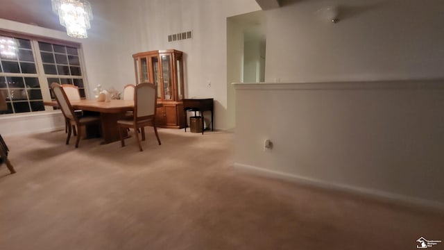 carpeted dining area featuring a notable chandelier