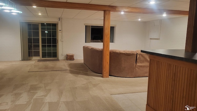 basement with brick wall and light carpet