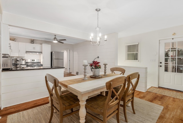 dining room featuring ceiling fan with notable chandelier and light wood-type flooring