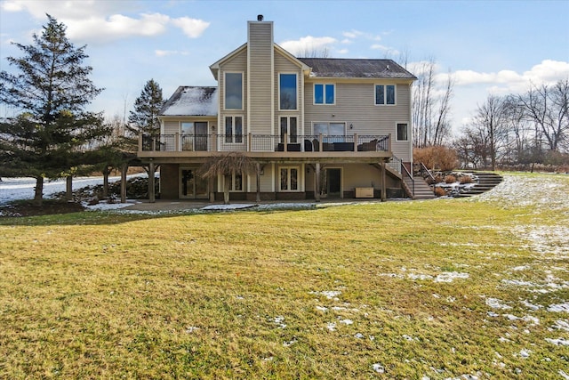 rear view of property featuring a yard, a patio, and a wooden deck