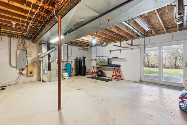 basement featuring electric panel and heating unit