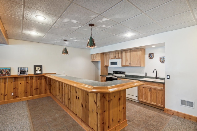 kitchen with pendant lighting, a drop ceiling, white appliances, sink, and kitchen peninsula