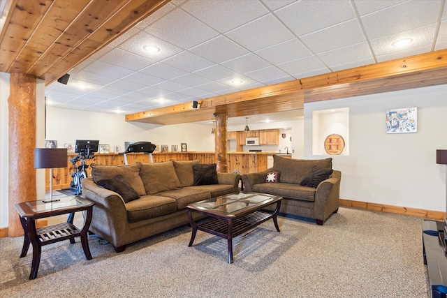 living room with carpet and a drop ceiling