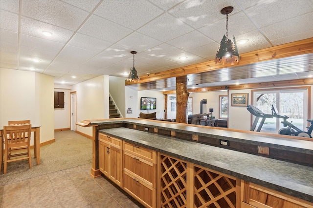 bar featuring a paneled ceiling, light carpet, and decorative light fixtures