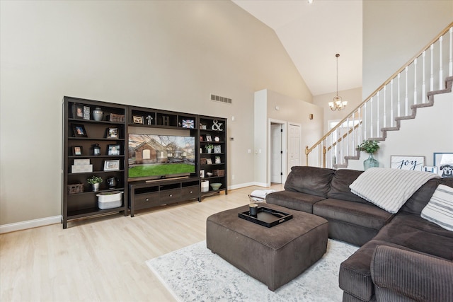 living room featuring hardwood / wood-style floors, high vaulted ceiling, and a chandelier