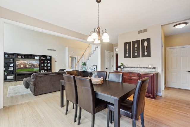 dining room featuring a notable chandelier and light wood-type flooring