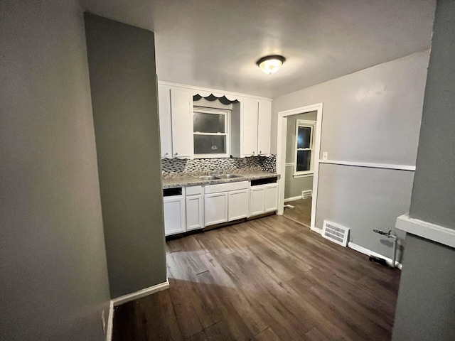 kitchen featuring decorative backsplash, white cabinetry, sink, and dark hardwood / wood-style floors