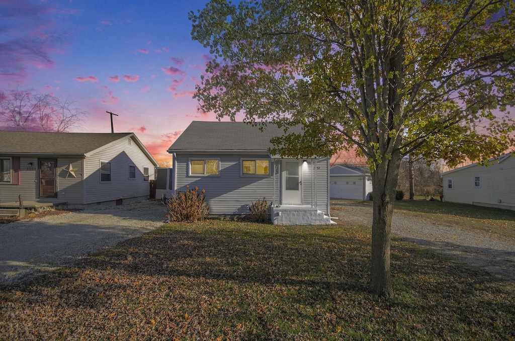 view of front of house featuring a garage and an outbuilding