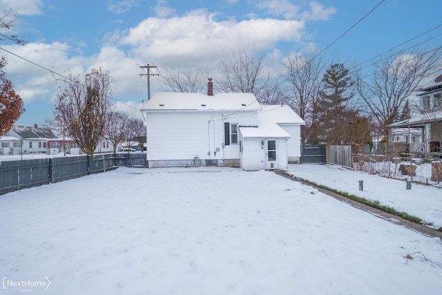 view of snow covered rear of property