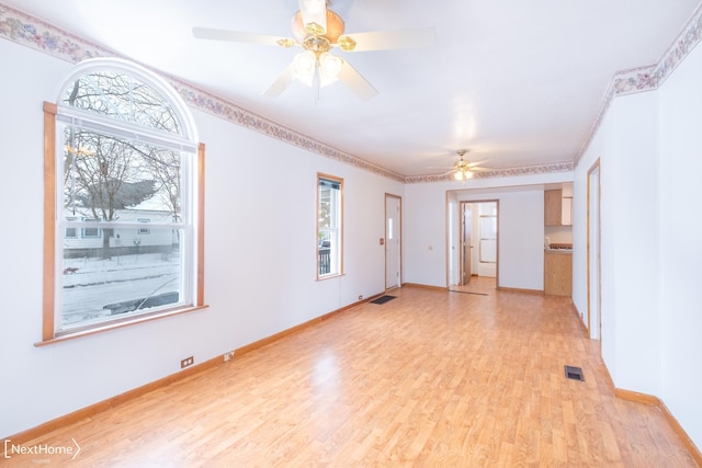 spare room with light hardwood / wood-style floors, ceiling fan, and ornamental molding