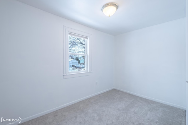 spare room featuring light carpet