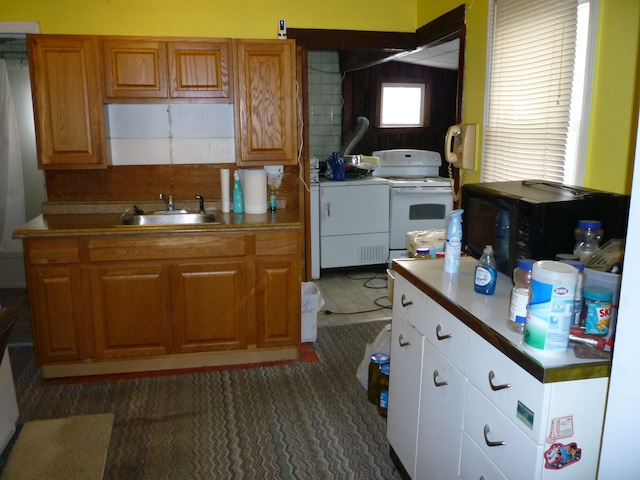 kitchen featuring white stove, decorative backsplash, washer / dryer, and sink