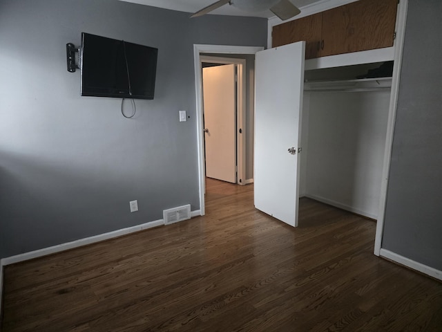 unfurnished bedroom featuring a closet, ceiling fan, and dark wood-type flooring