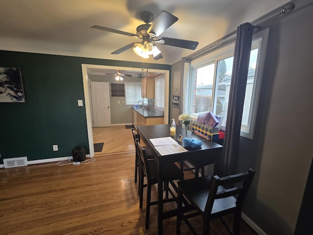 dining area with ceiling fan and hardwood / wood-style flooring