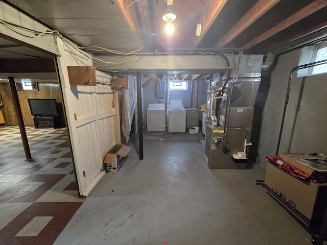 basement featuring plenty of natural light, washing machine and dryer, electric panel, and heating unit