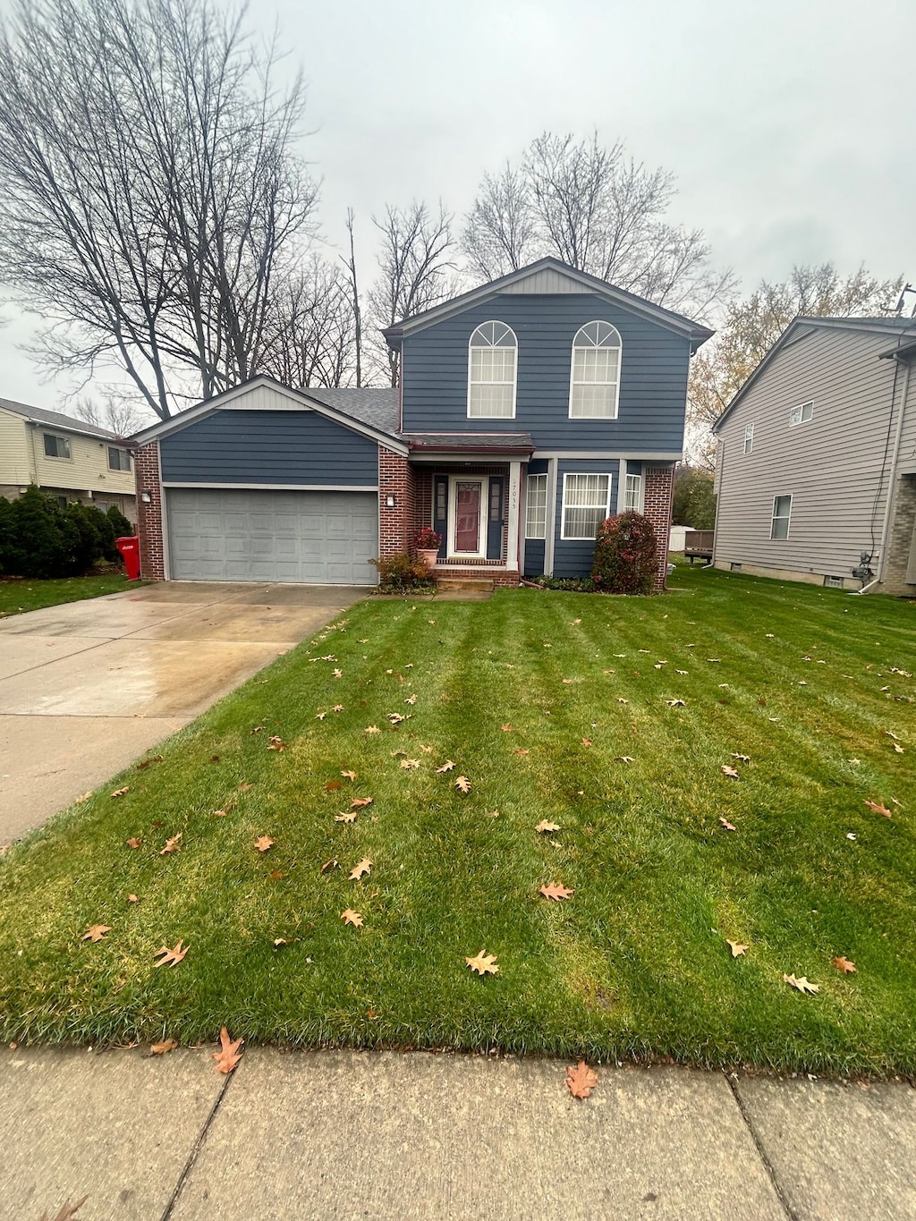 front facade with a garage and a front lawn