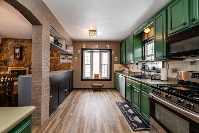 kitchen with green cabinets, a wealth of natural light, sink, and appliances with stainless steel finishes