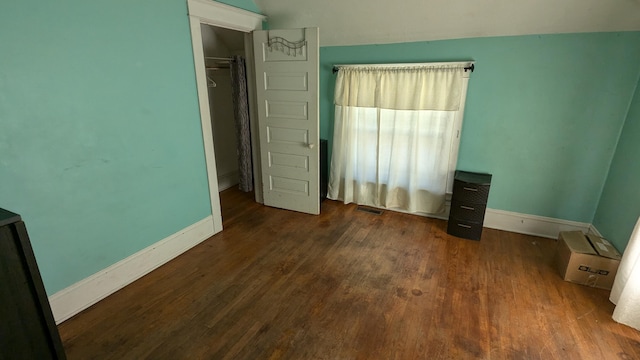 2521 Hillside Dr NW, Grand Rapids, MI 49544 - unfurnished bedroom featuring baseboards, wood finished floors, and lofted ceiling