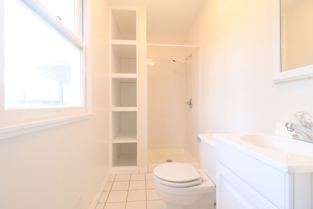 bathroom featuring toilet, vanity, tiled shower, and tile patterned floors