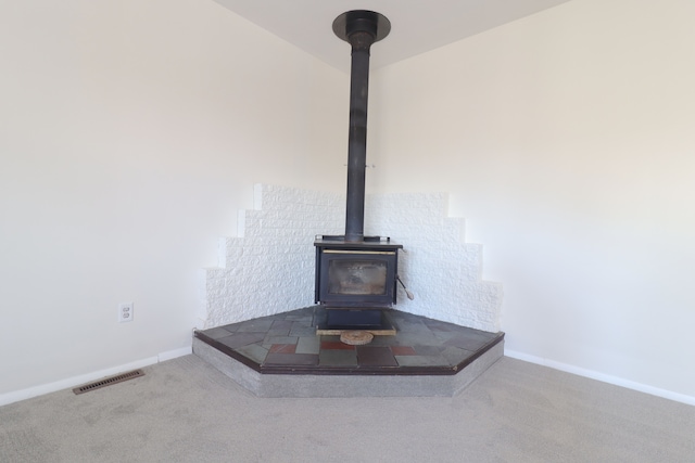 interior details with carpet floors and a wood stove