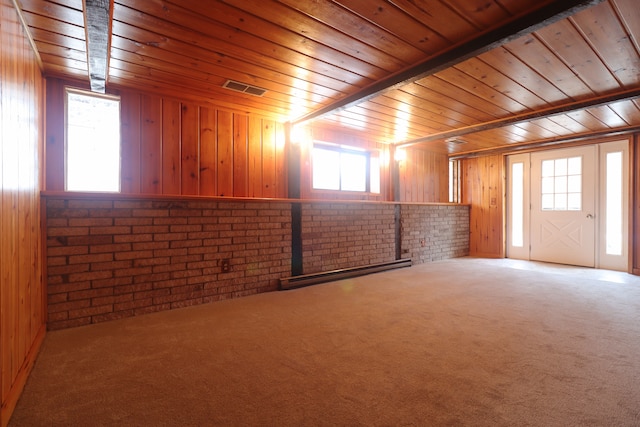 basement featuring carpet flooring, wood walls, wooden ceiling, and brick wall