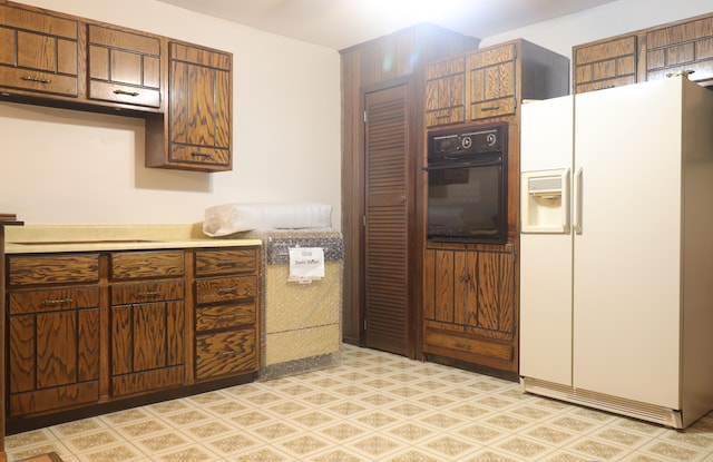 kitchen featuring white fridge with ice dispenser and oven