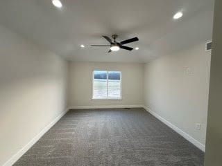 unfurnished room featuring dark colored carpet and ceiling fan