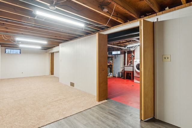 basement with washer / dryer and dark hardwood / wood-style floors