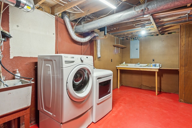 clothes washing area featuring a workshop area, separate washer and dryer, sink, and electric panel