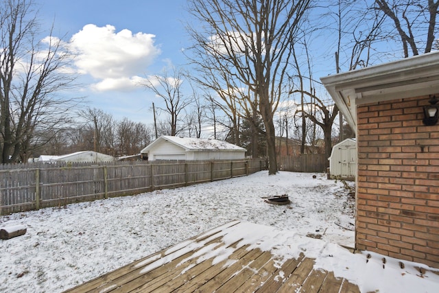 yard layered in snow with a shed