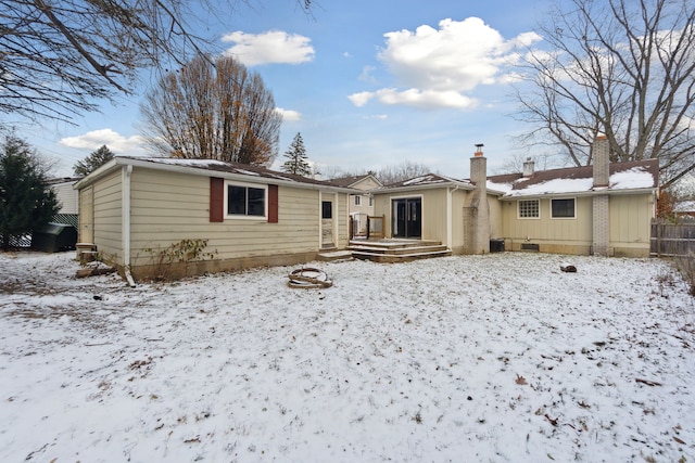 snow covered rear of property featuring a wooden deck