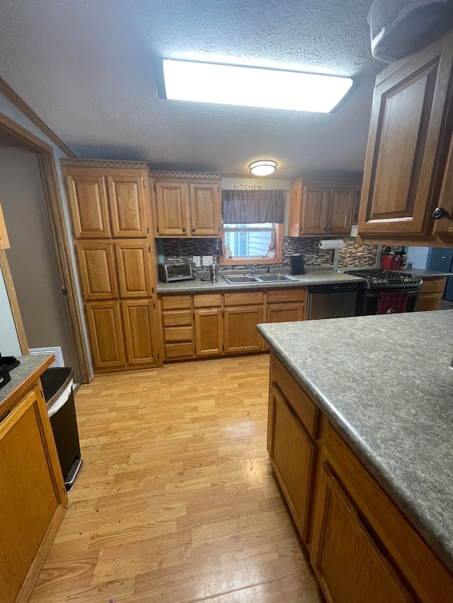 kitchen with tasteful backsplash, stainless steel dishwasher, sink, and light wood-type flooring