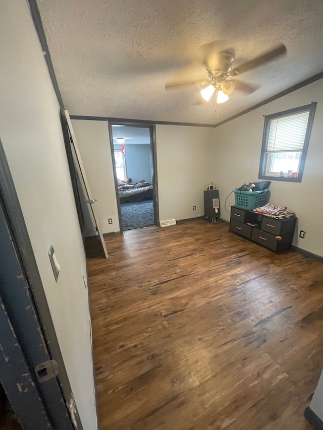 spare room featuring ceiling fan, dark hardwood / wood-style flooring, and a textured ceiling