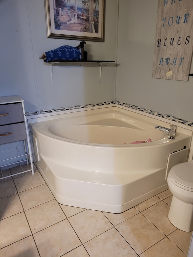 bathroom with tile patterned floors, a tub, and toilet