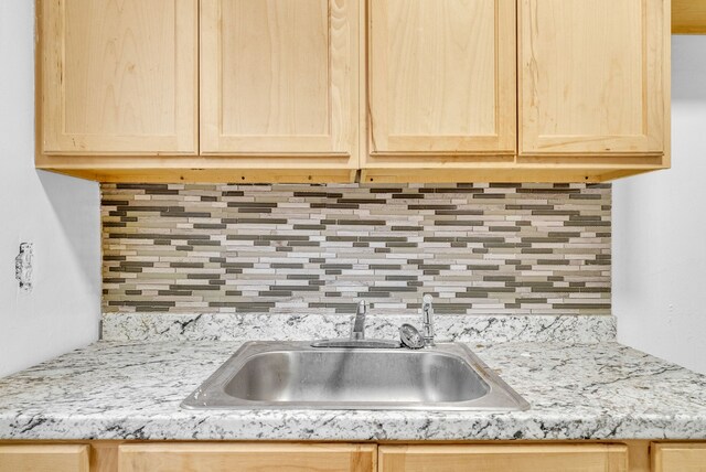 kitchen featuring backsplash, sink, and light brown cabinets