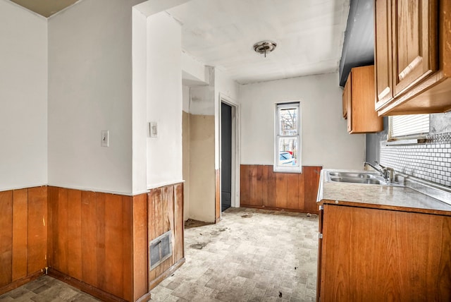 kitchen featuring wooden walls and sink