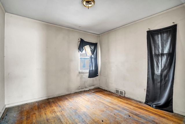 spare room with hardwood / wood-style floors and ornamental molding