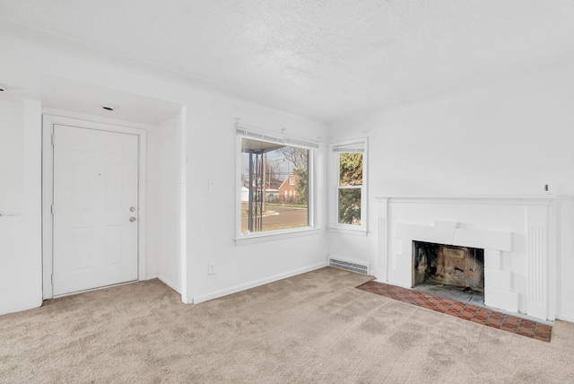 unfurnished living room featuring light colored carpet and a textured ceiling