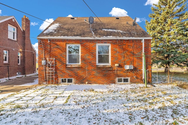 view of snow covered rear of property