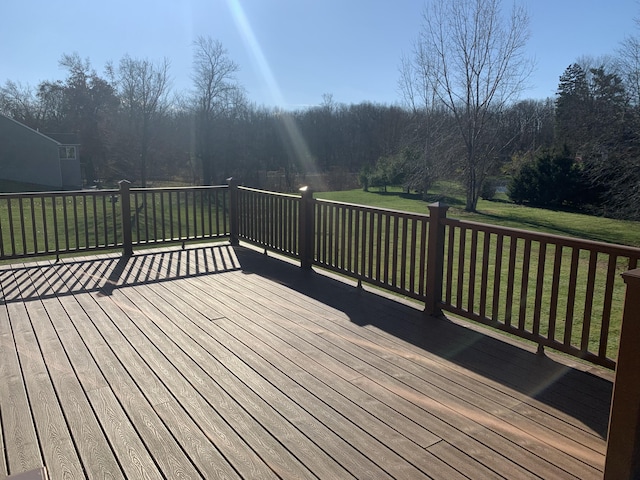 wooden deck featuring a lawn