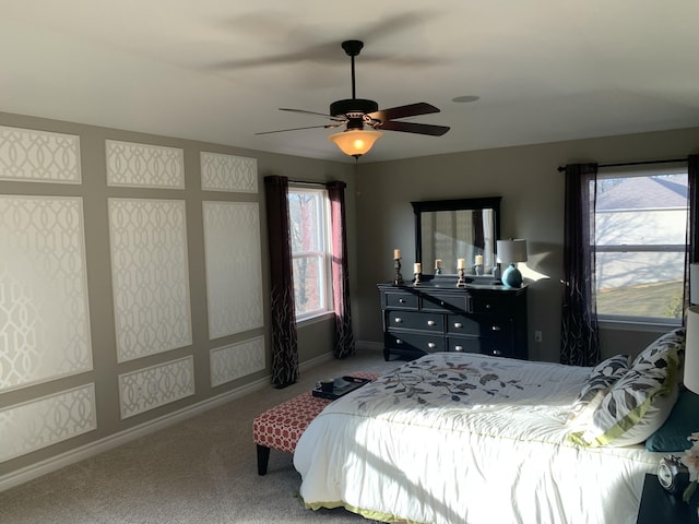 bedroom with carpet floors, multiple windows, and ceiling fan