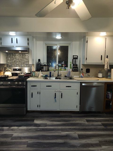 kitchen featuring white cabinets, sink, dark hardwood / wood-style floors, appliances with stainless steel finishes, and tasteful backsplash