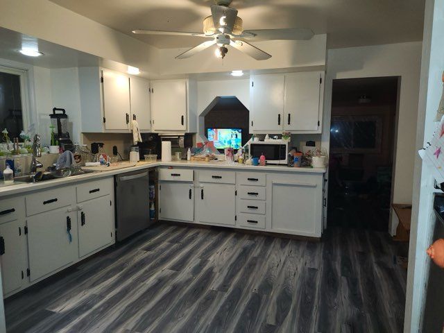 kitchen featuring white cabinets, appliances with stainless steel finishes, dark wood-type flooring, and sink