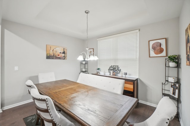 dining room with dark wood-type flooring and an inviting chandelier