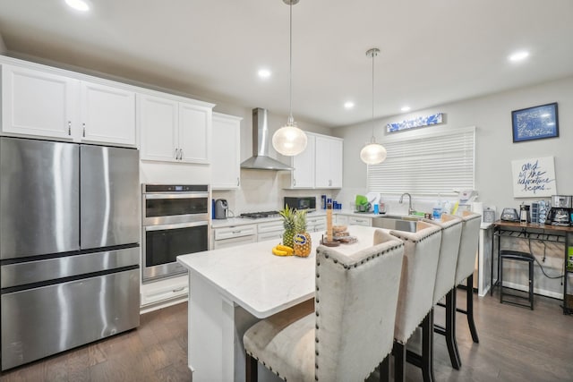 2785 Tulip Way, Commerce Twp, MI 48382 - kitchen with appliances with stainless steel finishes, wall chimney exhaust hood, recessed lighting, a kitchen island, and white cabinets