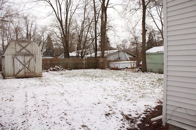 yard layered in snow featuring a storage unit