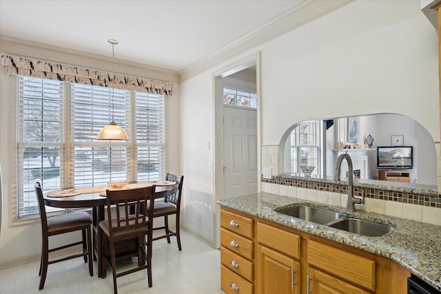 kitchen with light stone counters, sink, and a wealth of natural light