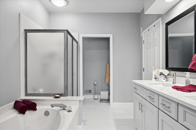 bathroom featuring separate shower and tub and vanity