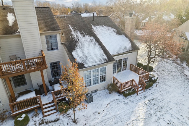 snow covered rear of property with central AC