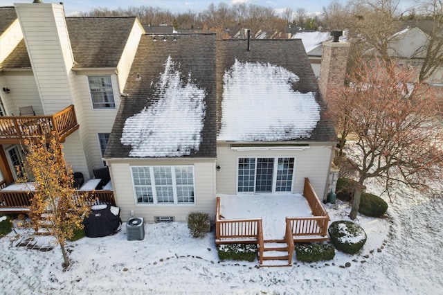 snow covered back of property with central air condition unit